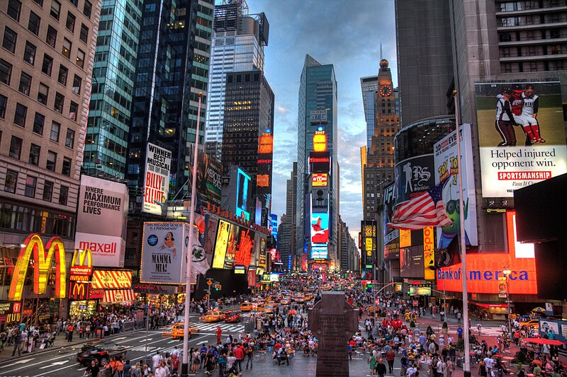 Times Square at night with illuminated billboards.